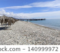 Sea waves crashing on the rocky shore with white foam on a sunny day. 140999972