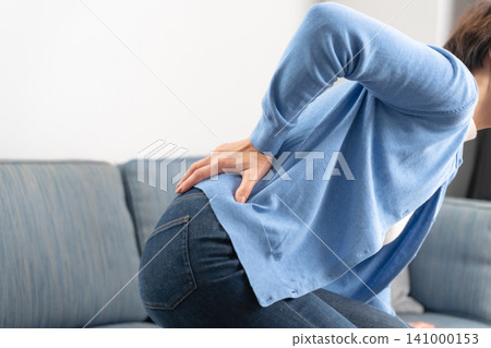 Female, lower back pain, hands Female, lower back pain, hands 141000153