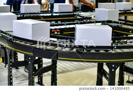 Automated conveyor belt system transporting blank white cardboard boxes in modern fulfillment warehouse logistics center Automated conveyor belt system transporting blank white cardboard boxes in modern fulfillment warehouse logistics center 141000485
