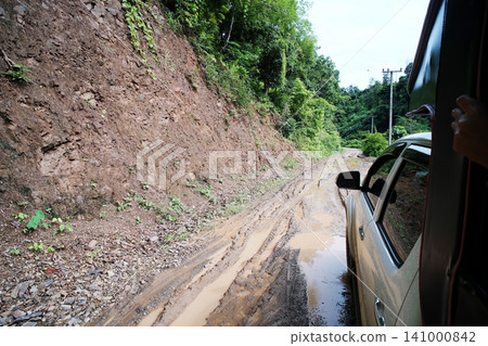 Off-road travel on a muddy and dirt road adventure on the mountain in rainy season of Thailand Off-road travel on a muddy and dirt road adventure on the mountain in rainy season of Thailand 141000842