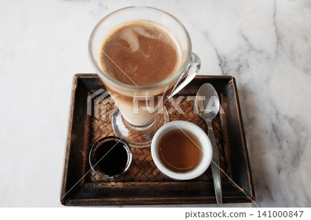 Top view of Iced latte coffee and hot black coffee with tea in a woven tray marble table Top view of Iced latte coffee and hot black coffee with tea in a woven tray marble table 141000847