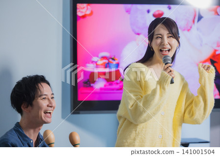 A man and a woman singing karaoke A man and a woman singing karaoke 141001504