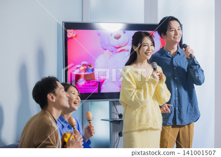 A man and a woman singing karaoke A man and a woman singing karaoke 141001507