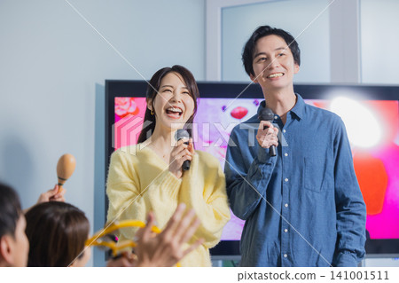 A man and a woman singing karaoke 141001511