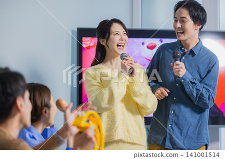 A man and a woman singing karaoke A man and a woman singing karaoke 141001514