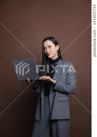 Smiling businesswoman with a laptop 141001733