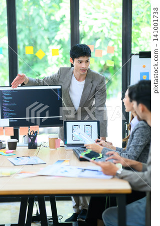 Asian Developer Team Brainstorming UI UX App Design in Modern Office Meeting with Code on Screen 141001738