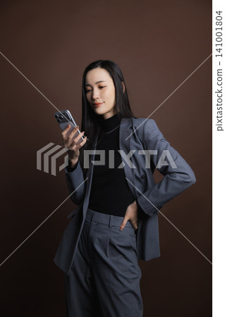 A young woman operating a smartphone A young woman operating a smartphone 141001804