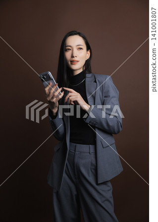 一個操作智能手機的年輕女子 141001807