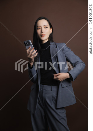一個操作智能手機的年輕女子 141001808