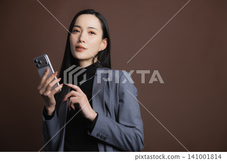 一個操作智能手機的年輕女子 141001814