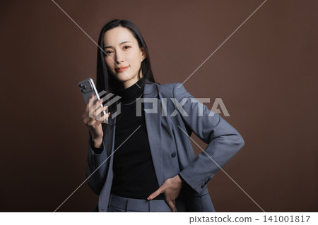 A young woman operating a smartphone A young woman operating a smartphone 141001817