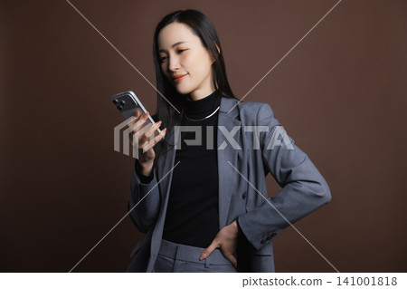 A young woman operating a smartphone A young woman operating a smartphone 141001818