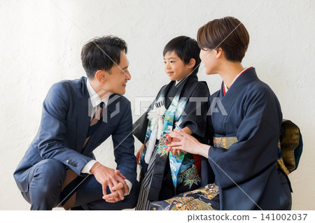 A boy wearing a hakama and his parents A boy wearing a hakama and his parents 141002037