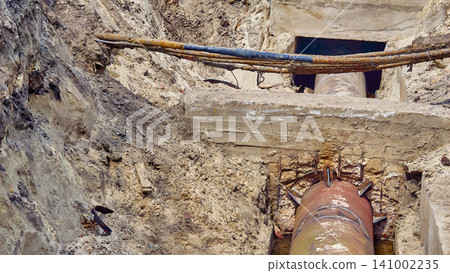 Preparing for replacement.Dug hole with metal water sewer pipes for repair Preparing for replacement.Dug hole with metal water sewer pipes for repair 141002235