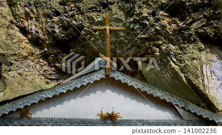 Roof ridge with a cross of a mountain rock Christian cave monastery Roof ridge with a cross of a mountain rock Christian cave monastery 141002236