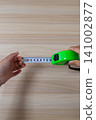 The hand that extends the measuring tape to measure length 141002877