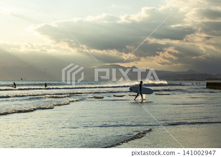 Shonan Kugenuma Beach: The sea and surfers bathed in the setting sun. Shonan Kugenuma Beach: The sea and surfers bathed in the setting sun. 141002947