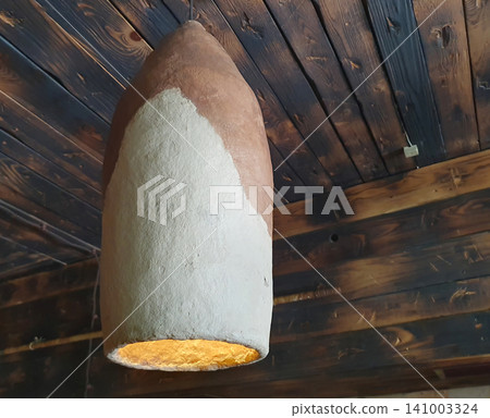 Rustic Handmade Clay Pendant Lamp Hanging from Wooden Ceiling Rustic Handmade Clay Pendant Lamp Hanging from Wooden Ceiling 141003324