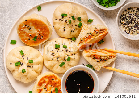 Delicious buns served on a plate with sauces and toppings Delicious buns served on a plate with sauces and toppings 141003611