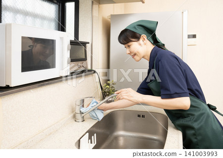 一位清潔女工正在清洗水槽 一位清潔女工正在清洗水槽 141003993