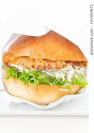 A delicious katsu burger wrapped in paper A delicious katsu burger wrapped in paper 141004673