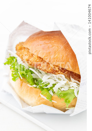 A delicious katsu burger wrapped in paper A delicious katsu burger wrapped in paper 141004674