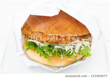 A delicious katsu burger wrapped in paper A delicious katsu burger wrapped in paper 141004677