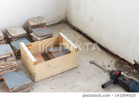 Old floor tiles are being removed from an open apartment balcony Old floor tiles are being removed from an open apartment balcony 141004920