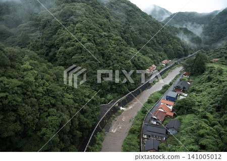 A mountain village and river landscape shrouded in fog after heavy rain. A mountain village and river landscape shrouded in fog after heavy rain. 141005012
