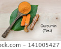 Turmeric powder in a wooden spoon and fresh turmeric roots on a wooden plate with copy space for text, highlighting natural herbal ingredients, organic wellness, and healthy nutrition concepts. 141005427