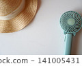 A portable fan and a straw hat 141005431