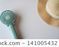 A handy fan and a straw hat for protection against the summer heat (image) 141005432