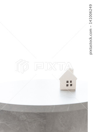 A small white house on a table, with white space (copy space) that can be used for real estate and housing-related concepts. 141006249