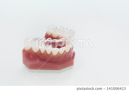 Clear aligner orthodontic appliance and dental model (product photo on a white background) Clear aligner orthodontic appliance and dental model (product photo on a white background) 141006423