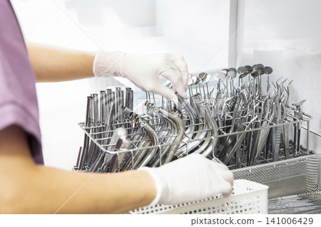 A scene from infection control where dental instruments are sorted into sterilization baskets. A scene from infection control where dental instruments are sorted into sterilization baskets. 141006429