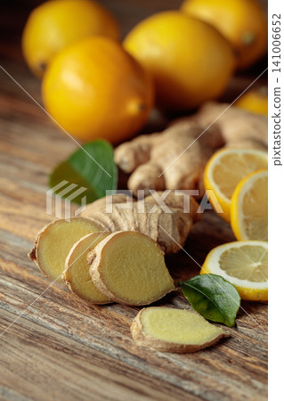 Ginger roots and fresh lemons on an old wooden table. Ginger roots and fresh lemons on an old wooden table. 141006652