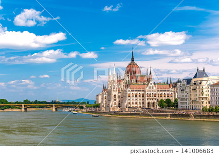 The magnificent Neo-Gothic Parliament building stands majestically on the banks of the Danube River in Budapest, Hungary. The magnificent Neo-Gothic Parliament building stands majestically on the banks of the Danube River in Budapest, Hungary. 141006683