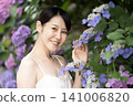 A smiling woman with hydrangeas 141006820