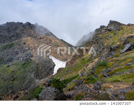 登山者站在陽光普照的山脊上 登山者站在陽光普照的山脊上 141007107