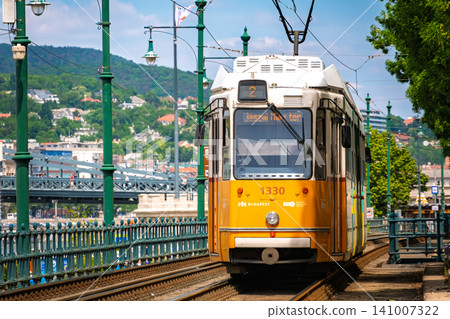 匈牙利布達佩斯:著名的黃色電車(電車)沿著多瑙河行駛。 匈牙利布達佩斯:著名的黃色電車(電車)沿著多瑙河行駛。 141007322