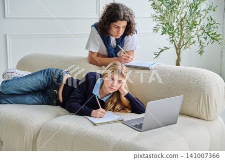 Two teenage students focused on studying with laptop 141007366