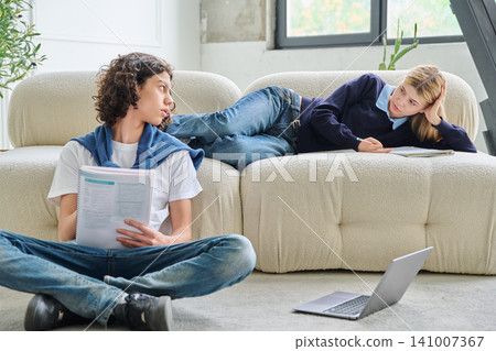 Two teenage students looking at each other at home Two teenage students looking at each other at home 141007367