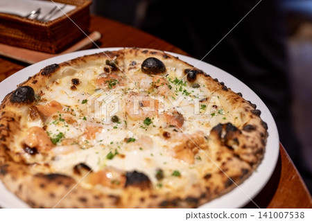 Authentic wood-fired seafood pizza with melted cheese Authentic wood-fired seafood pizza with melted cheese 141007538