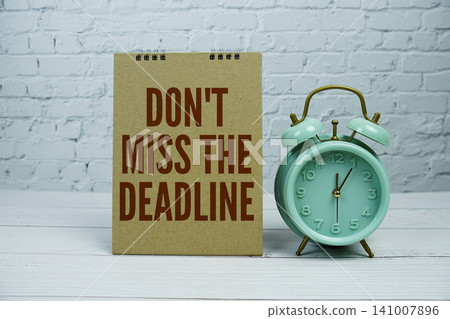 "Don't Miss The Deadline" Reminder with Mint Green Alarm Clock on white brick wall Background "Don't Miss The Deadline" Reminder with Mint Green Alarm Clock on white brick wall Background 141007896