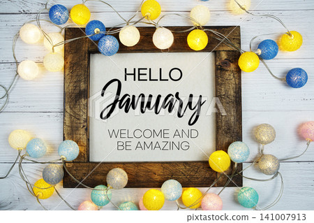 Hello January text with LED cotton ball decoration on wooden background Hello January text with LED cotton ball decoration on wooden background 141007913