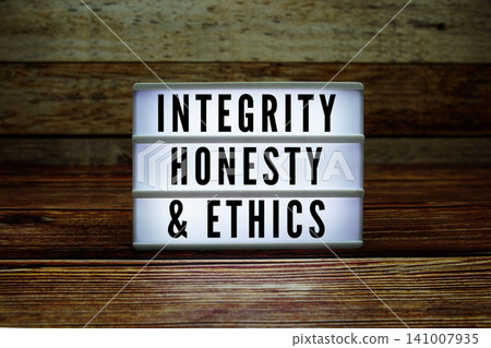 Lightbox with text "Integrity, Honesty, And Ethics" on wooden background 141007935