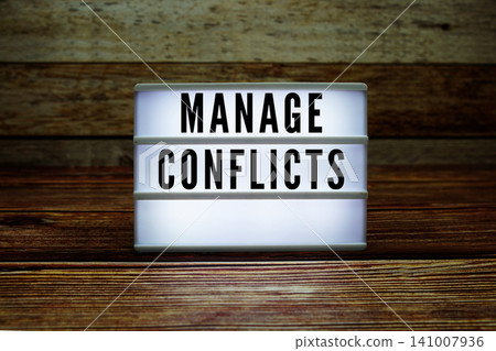 Lightbox with text "Manage Conflicts" on wooden background Lightbox with text "Manage Conflicts" on wooden background 141007936