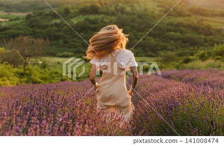 Carefree Woman Running through Purple Lavender Field Carefree Woman Running through Purple Lavender Field 141008474