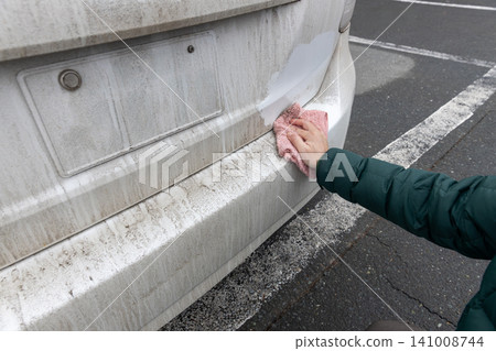 I'm wiping the dirty car body with a damp cloth. 141008744